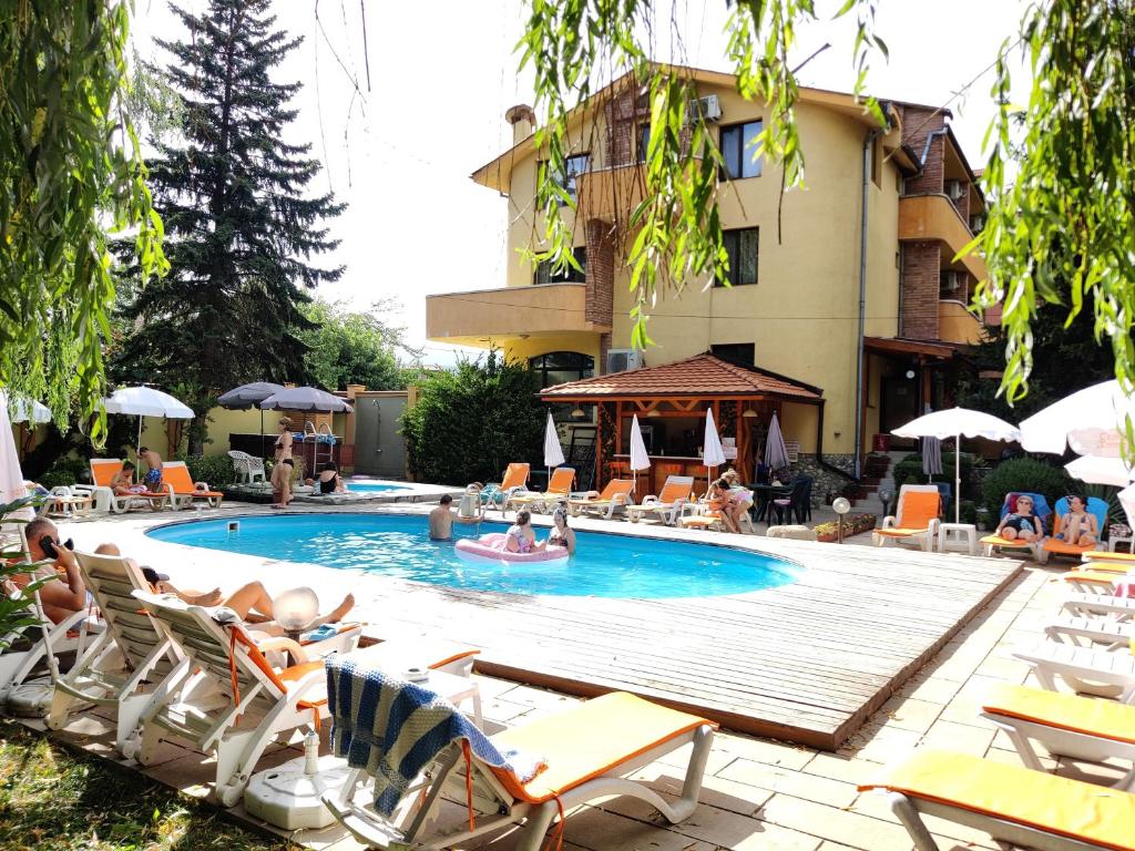 uma piscina com espreguiçadeiras e um hotel em Family Hotel Iv em Velingrad