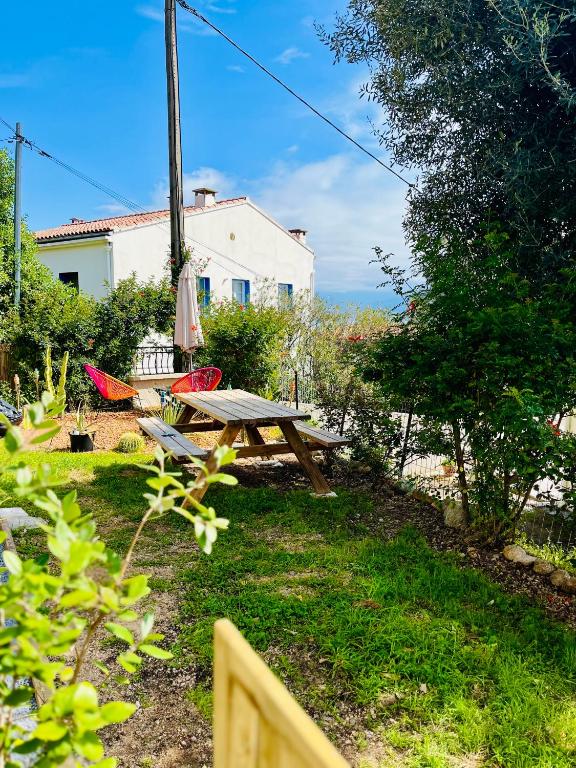 - une table de pique-nique et des chaises dans la cour dans l'établissement La cave marine du Trottel, à Ajaccio