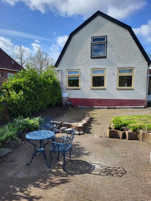 a table and chairs in front of a house at vakantie appartement Stadskanaal in Stadskanaal