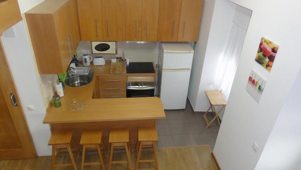 uma pequena cozinha com uma mesa e um frigorífico em Quinta do Chico Feijão em Lajes