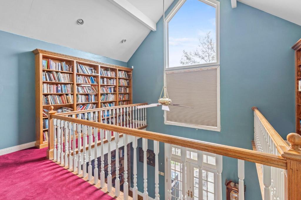 a room with a staircase with bookshelves and a window at Lake Charles Luxe: Casino Escape in Lake Charles