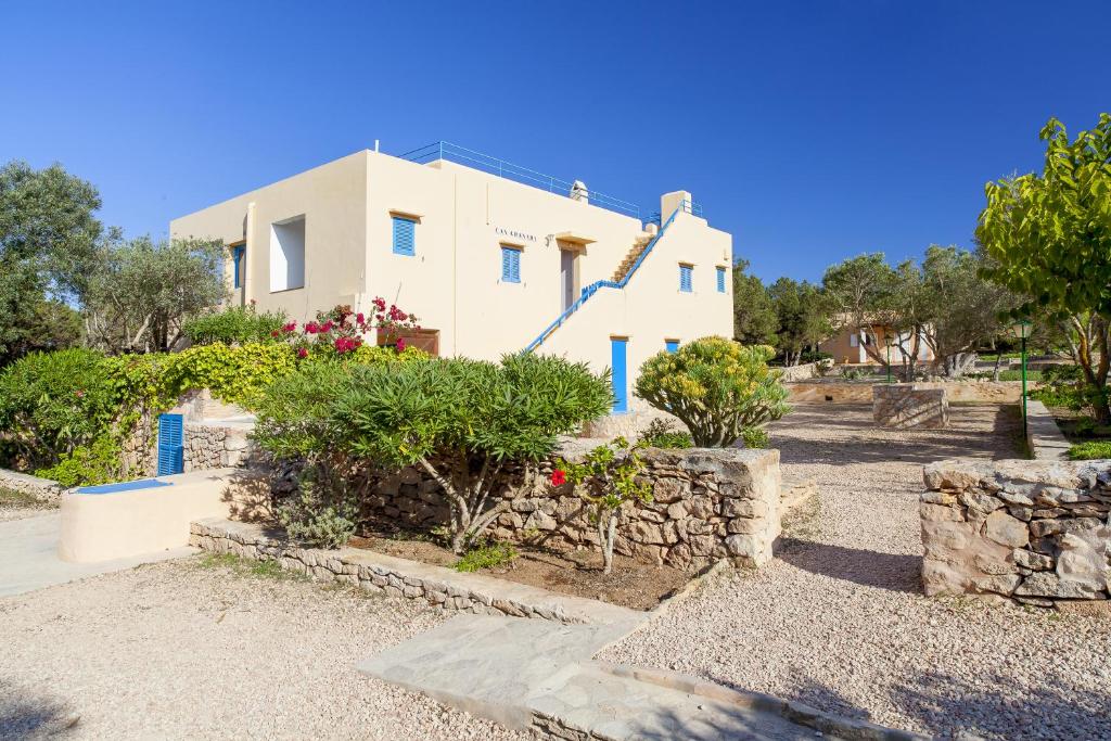 una casa bianca con alberi e cespugli di fronte di Can Granada a Es Pujols