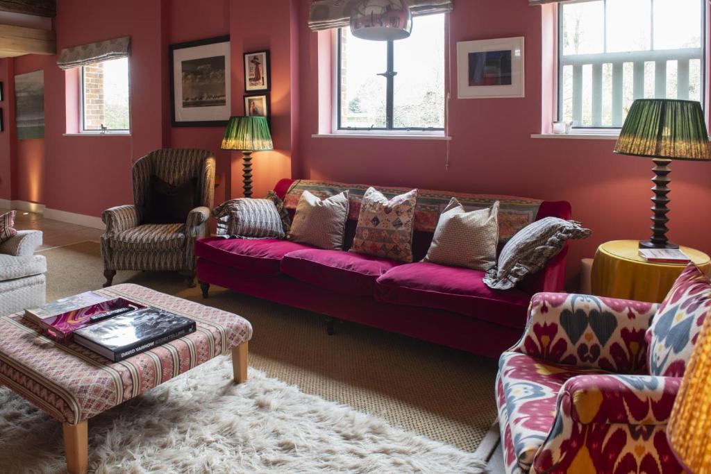 a living room with red walls and a red couch at Fabulous Farmhouse in Hampshire in London