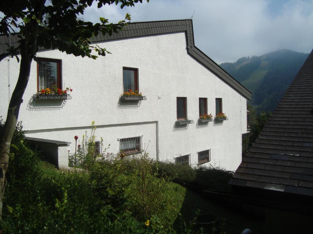 un bâtiment blanc avec des boîtes de fleurs sur les fenêtres dans l'établissement Semmering Villa Sonnenschein, à Semmering