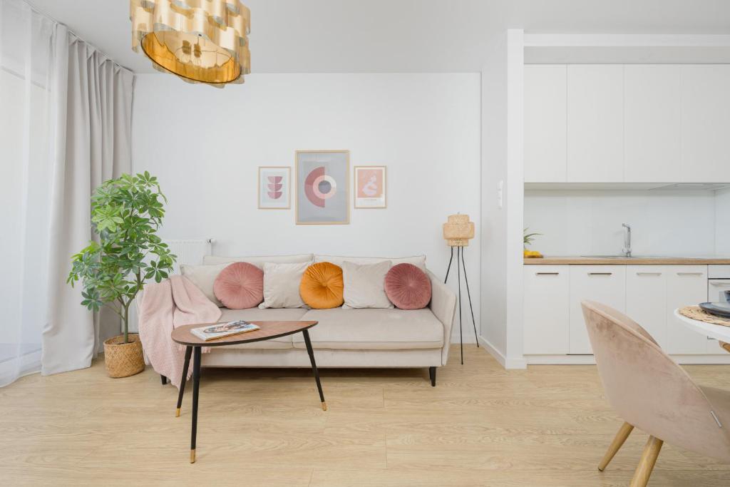 a white living room with a couch and a table at Stylish Glam Apartment Przedpole in Warsaw by Renters in Warsaw