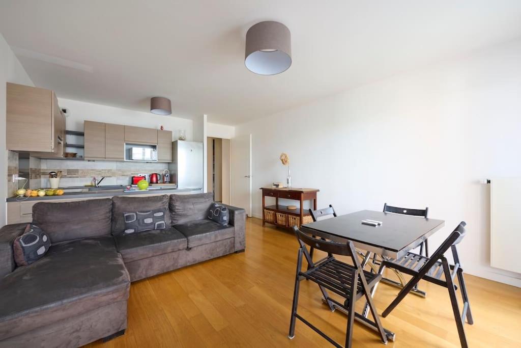 un salon avec un canapé et une table dans l'établissement Cosy appartement direct PARIS La Défense, à Rueil-Malmaison