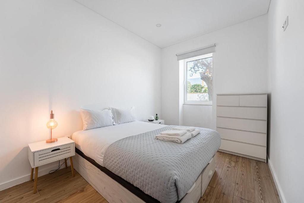 ein weißes Schlafzimmer mit einem Bett und einem Fenster in der Unterkunft GuestReady - Ílhavo Divine Encounters in Ílhavo