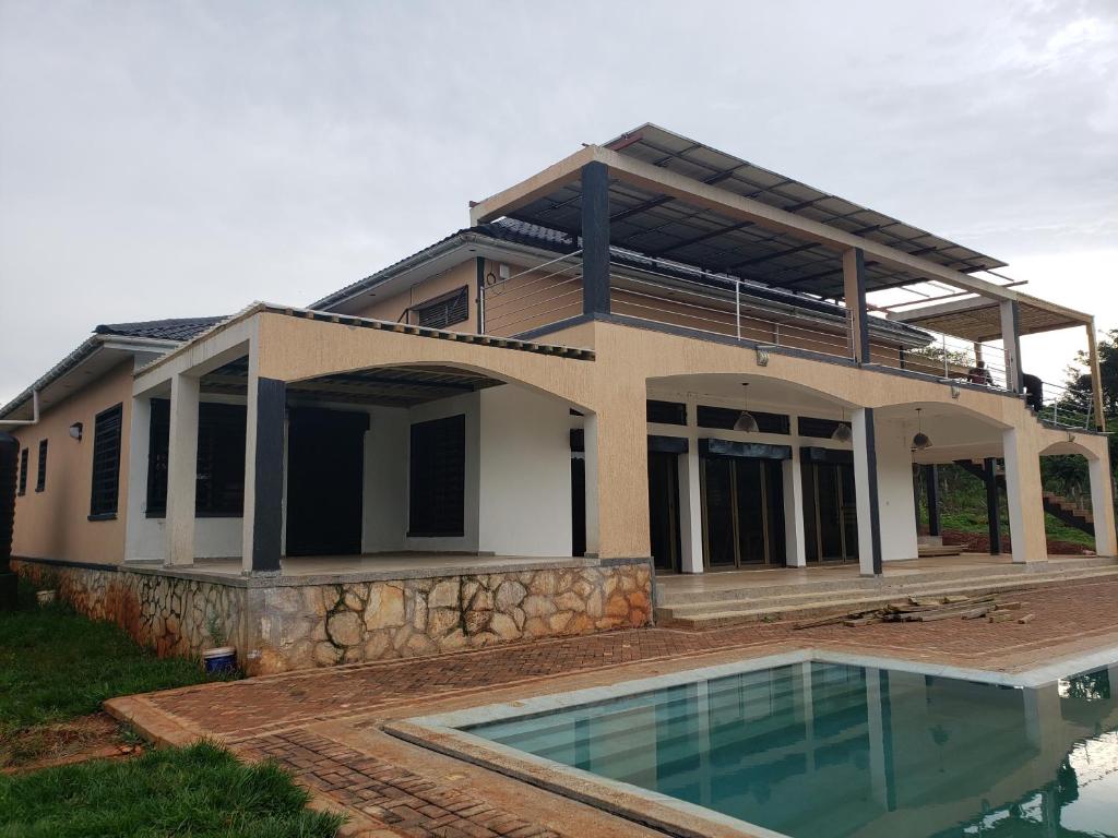 a house with a swimming pool in front of it at Grand Grove in Jinja