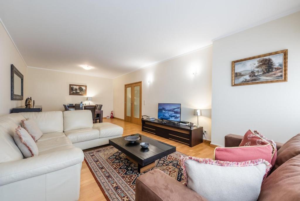 ein Wohnzimmer mit einem Sofa und einem Tisch in der Unterkunft GuestReady - Espinho Lux in Porto