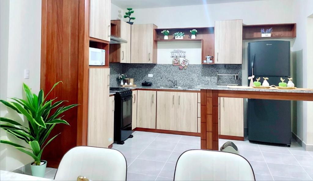cocina con sillas blancas y nevera negra en Sunset Home 2B (Gated), en Higüey
