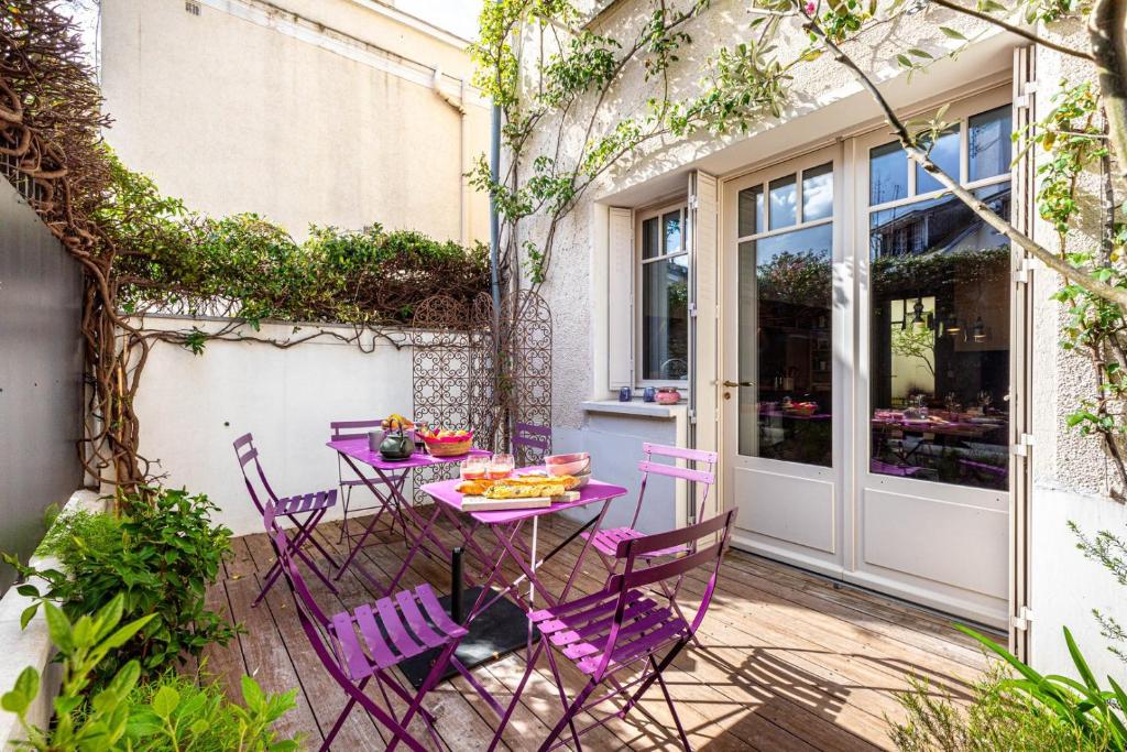 une table et des chaises violettes sur la terrasse dans l'établissement GuestReady - Maison de Charme près de la Nature, à Boulogne-Billancourt