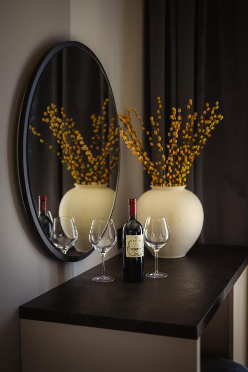 a table with two glasses and a bottle of wine at Winery Rizman B&B in Slivno Ravno