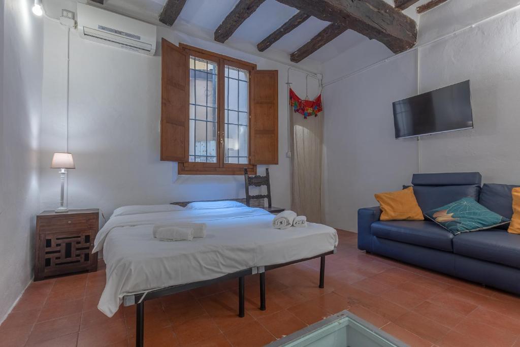 un salon avec un lit et un canapé dans l'établissement Central Apartment With Private Courtyard!, à Bologne