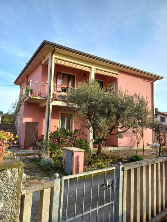 a pink house with a fence in front of it at Affittacamere l'Aurora in Ceparana