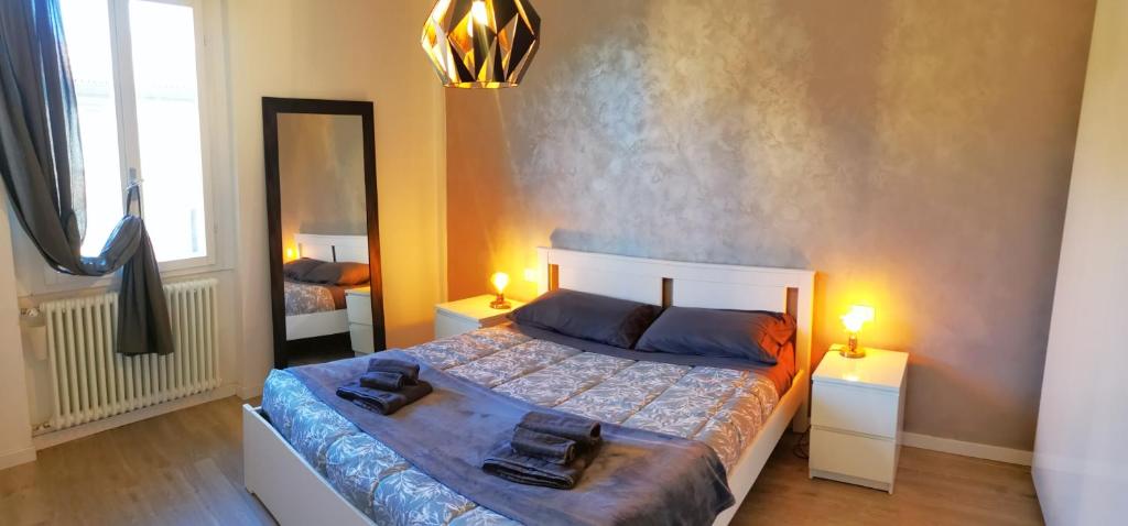 una camera con un letto con due lampade e uno specchio di Bologna Holiday House a Bologna