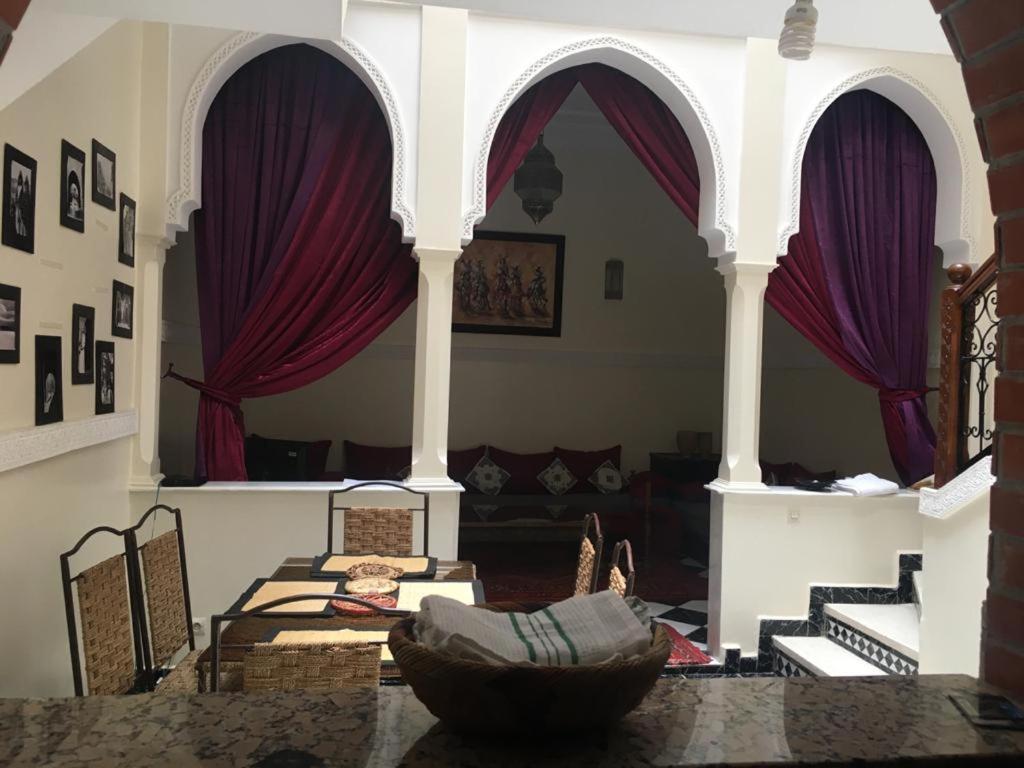 a living room with purple curtains and a couch at Riad Hicham in Marrakesh