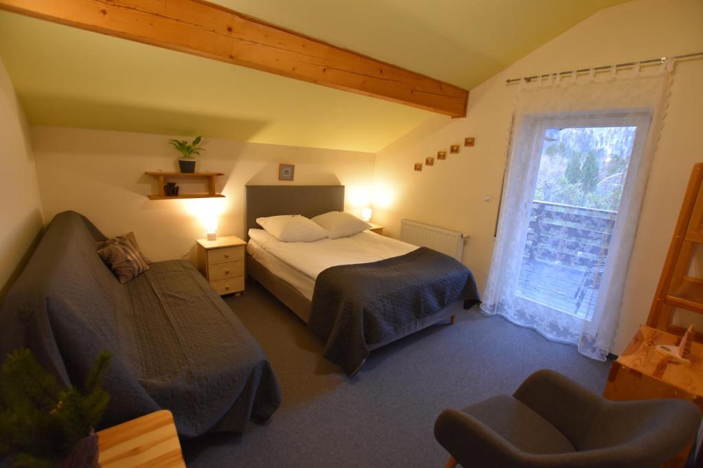 シュチルクにあるApartamenty Czyrna przy Gondoliのベッドルーム1室(ベッド1台、椅子、窓付)