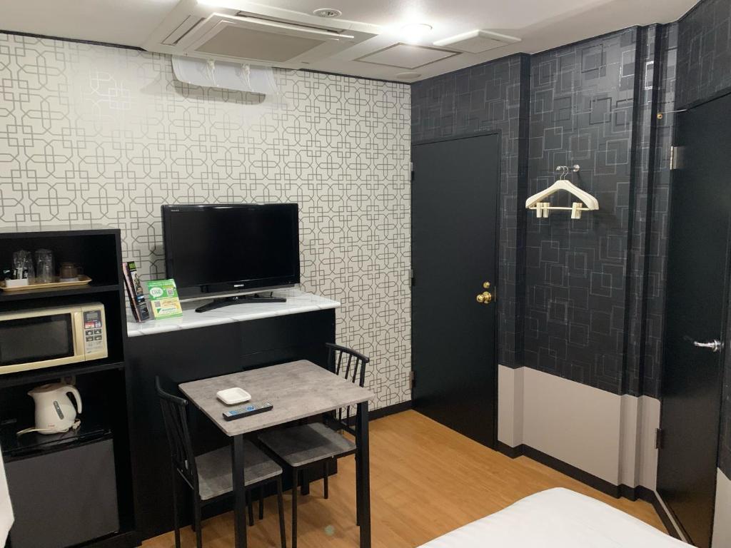 een kamer met een kleine tafel en een televisie bij ホテル　るテラスⅡ in Sendai