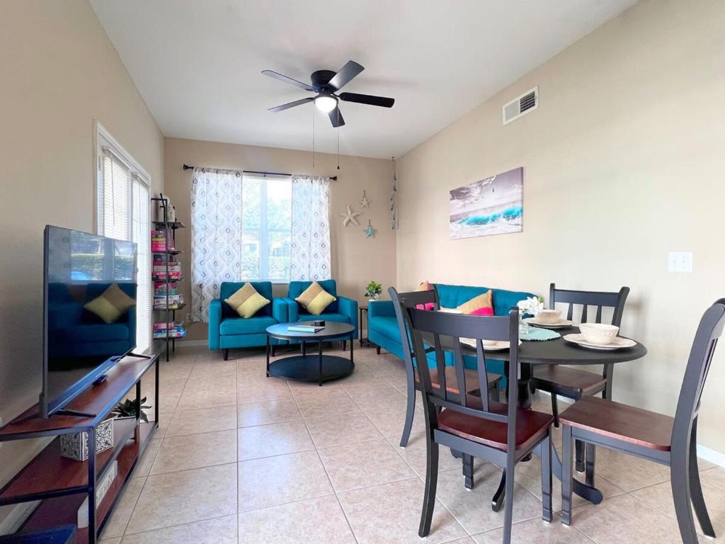 a living room with a blue couch and a table at Sunshine Retreat 4 Bed Town Home-4017VBD in Kissimmee