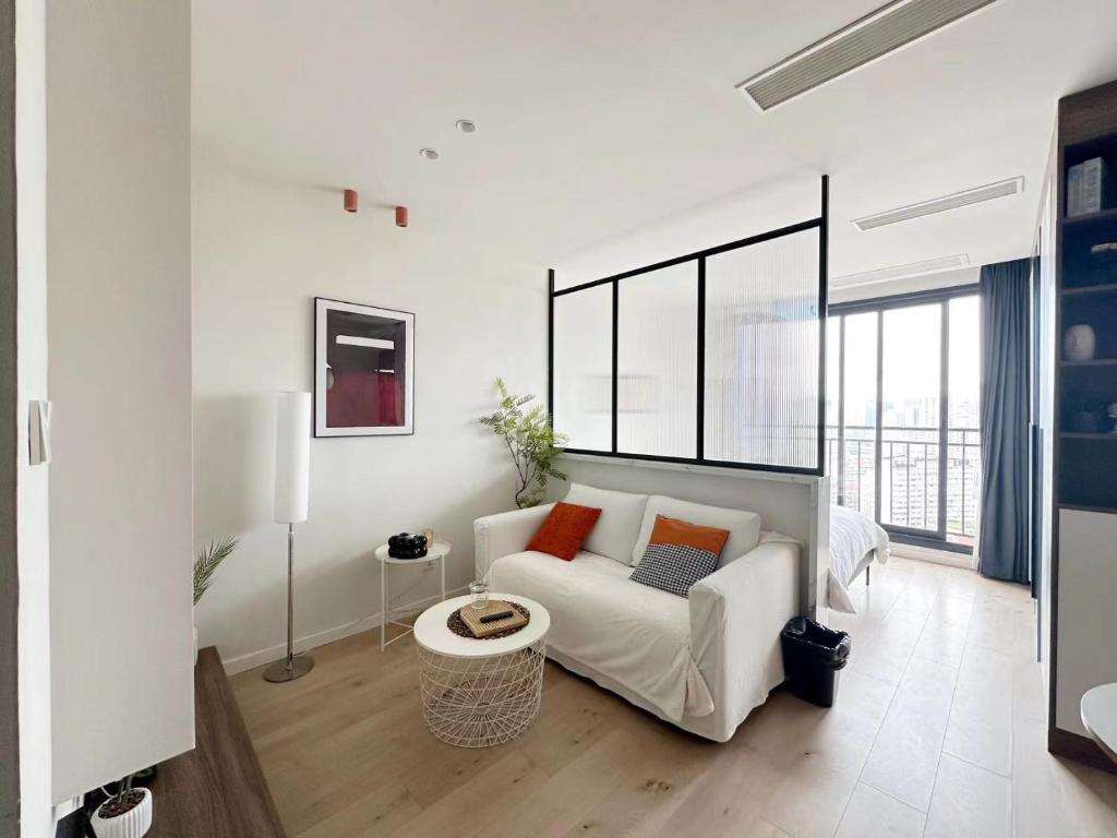 a white living room with a couch and a table at 同济佳苑公寓 in Shanghai