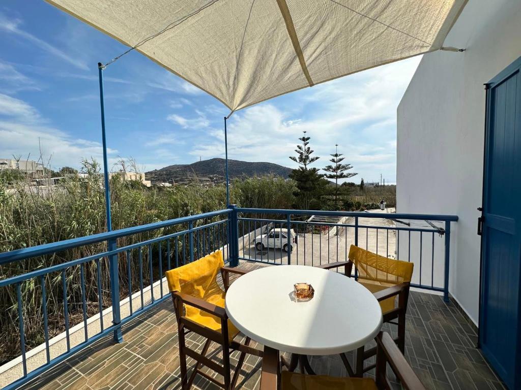 balcón con mesa blanca, sillas y vistas en ΔΙΑΜΕΡΙΣΜΑΤΑ-STUDIO ANTONIA, en Galissas
