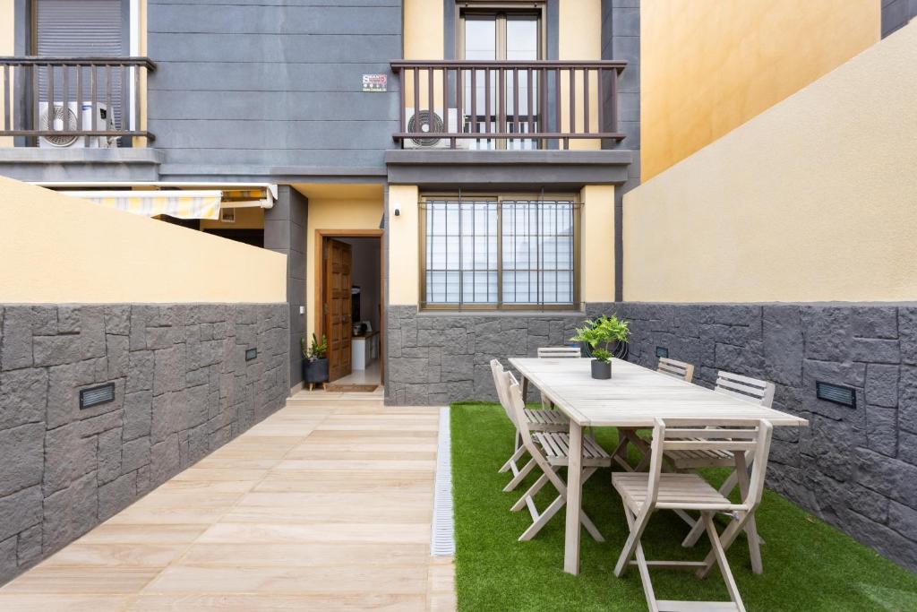 een patio met een tafel en stoelen op het gras bij Villa Mencey in San Miguel de Abona