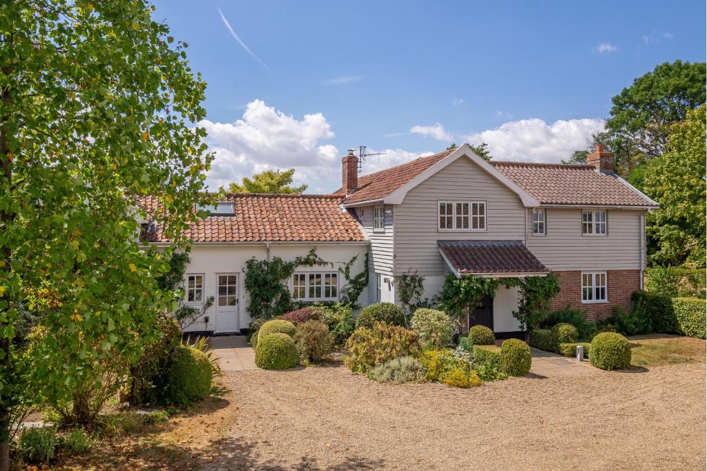 ein großes weißes Haus mit einem Garten mit Büschen in der Unterkunft Foxhole Cottage 8 in Stowmarket