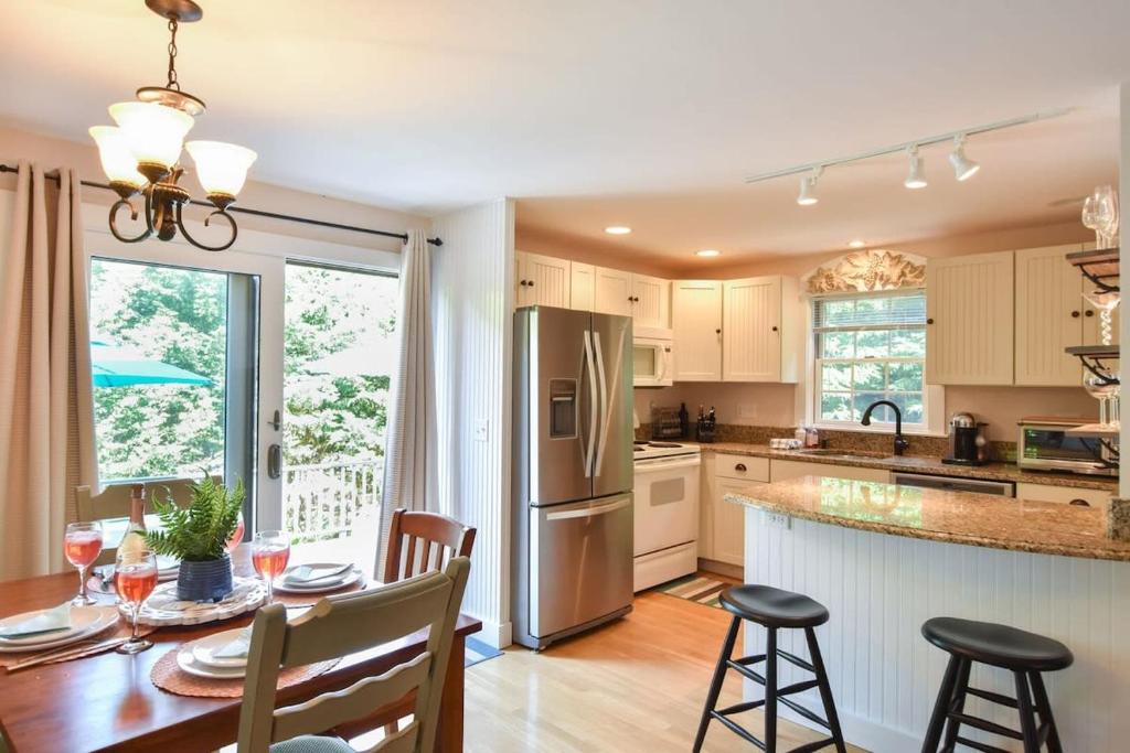 a kitchen with a table and a refrigerator at Private Patio Walk to Commercial St in Provincetown