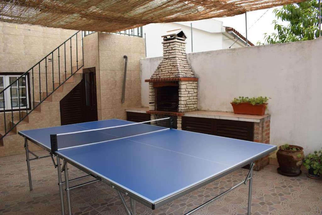 una mesa de ping pong azul frente a un horno de ladrillo en Village House in Alto Alentejo, en Arez