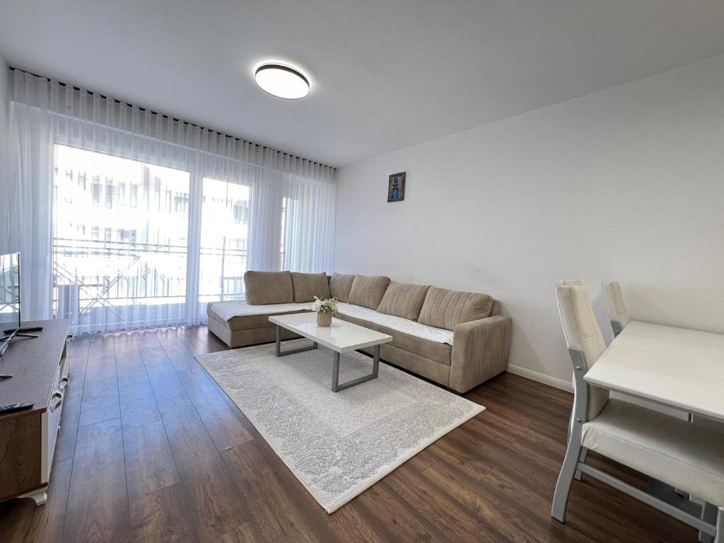 een woonkamer met een bank en een tafel bij City Center 1bedroom in Ferizaj