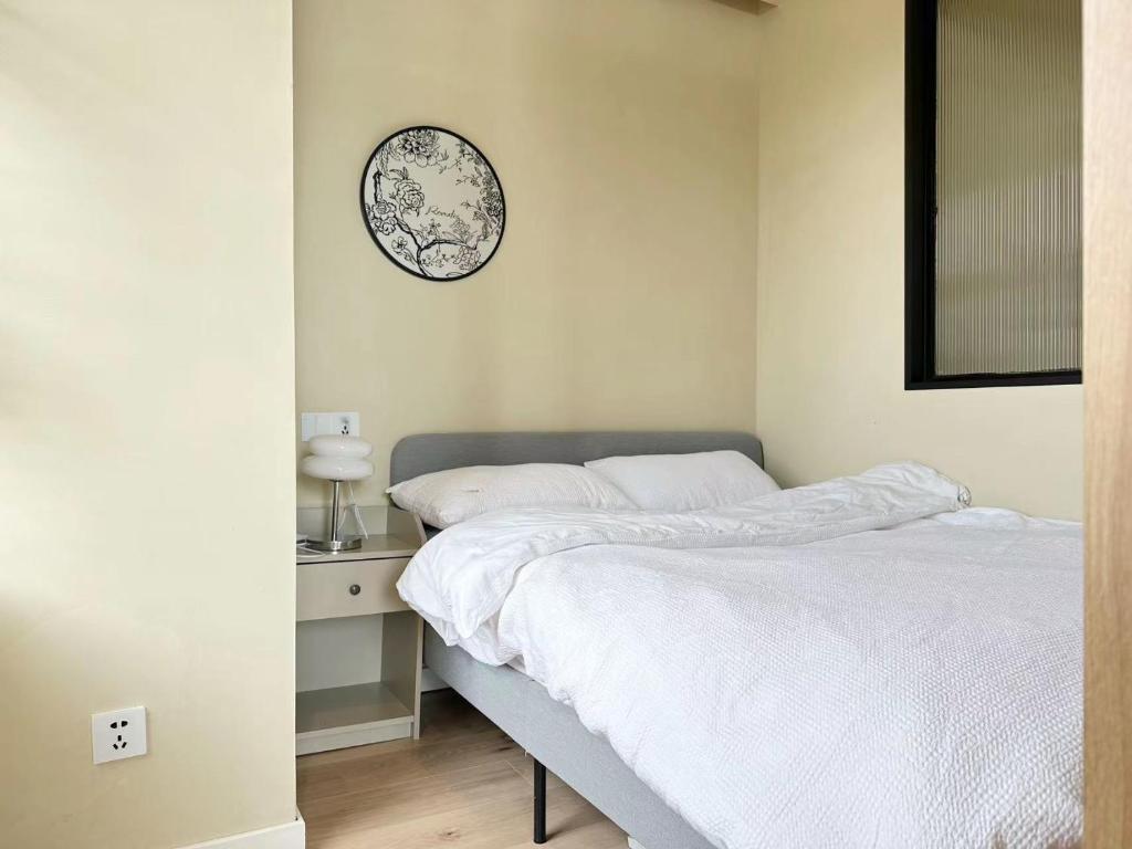 a bedroom with a bed and a clock on the wall at 同济佳苑公寓 in Shanghai