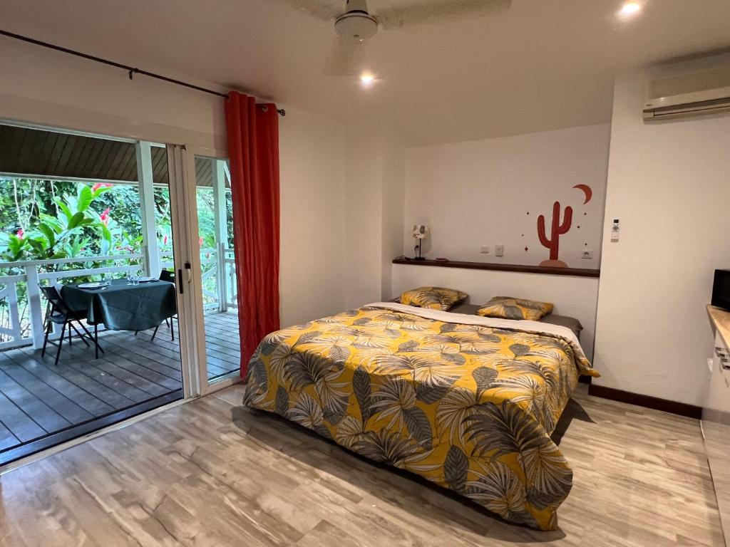 a bedroom with a bed and a sliding glass door at Bungalow Terra - Sarramea in Sarraméa
