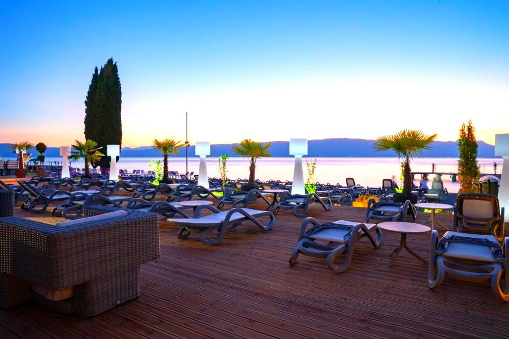 eine Gruppe von Stühlen und Tischen auf einer Terrasse in der Unterkunft Park Golden View Hotel Casino in Ohrid