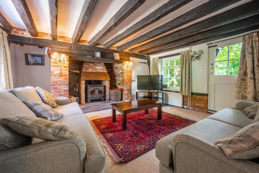 a living room with two couches and a fireplace at Peak Hill Cottage 4 in Theberton