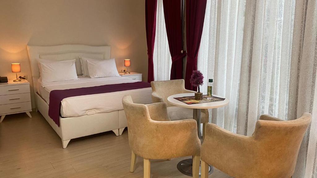 1 dormitorio con 1 cama, mesa y sillas en Chez Bore Butique Hotel en Estambul