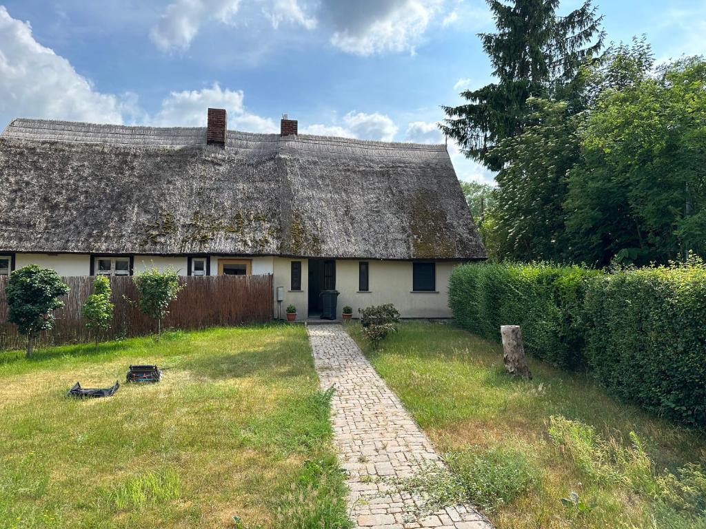 an old house with a thatched roof in a yard at Ferienwohnung Fischerhaus in Rankwitz
