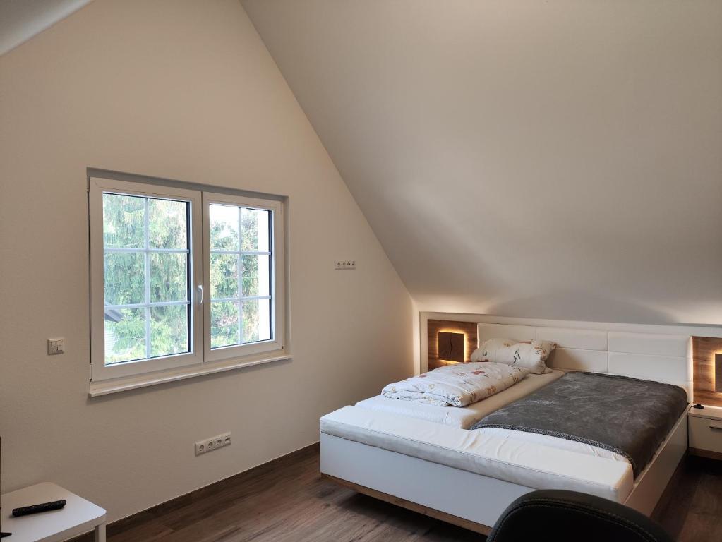 una camera con letto e finestra di Ferienwohnung Völkel a Röllbach
