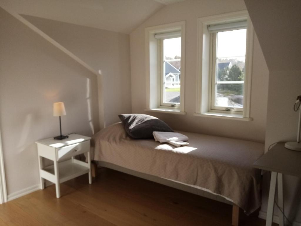 a bedroom with a bed and two windows at Gula huset in Gothenburg