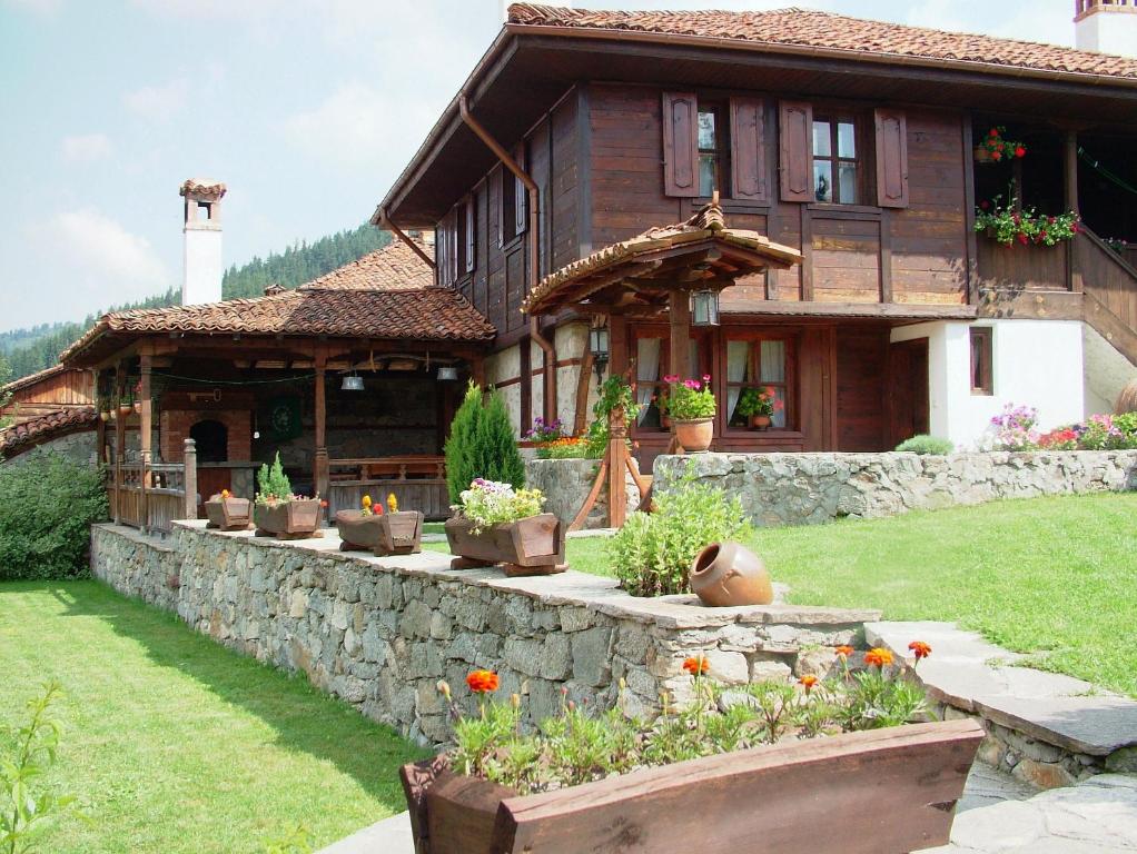 a house with flowers in front of it at Hadji Neikovi Guest Houses in Koprivshtitsa