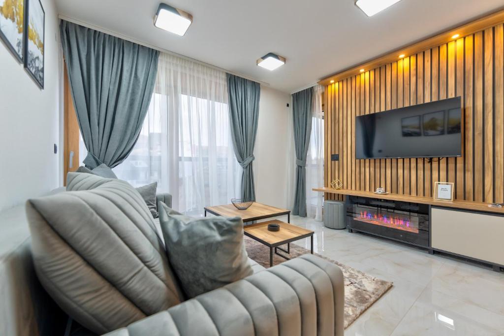a living room with a couch and a television at Golden Panorama Spa & Wellness in Zlatibor