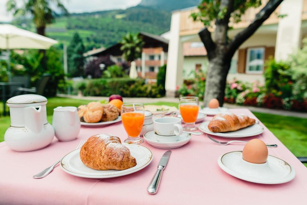 różowy stół z jajkami i rogalikami w obiekcie Felsenegg w mieście Nals