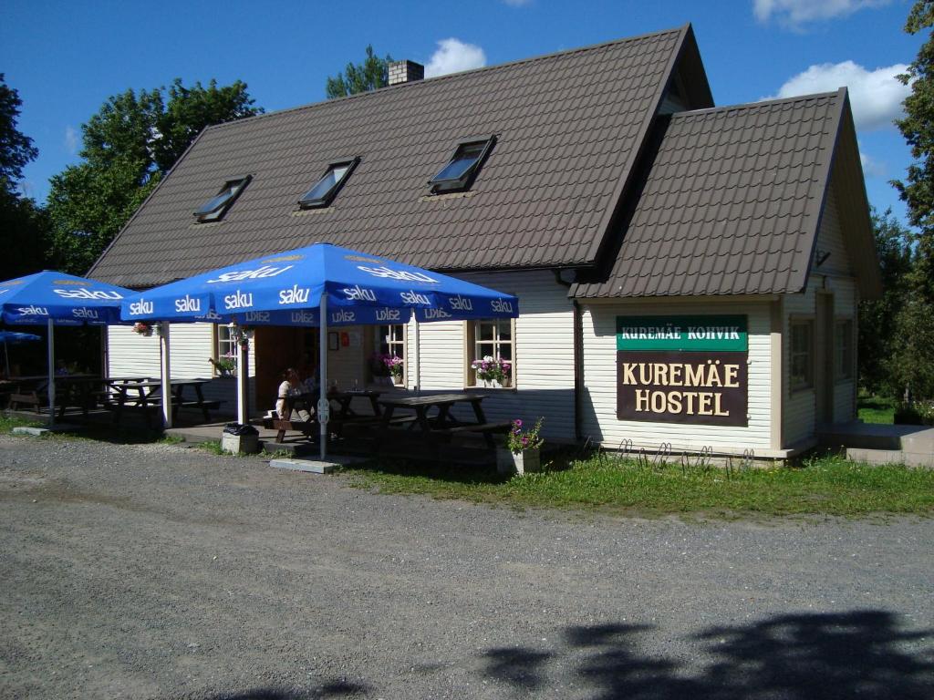 een huis met blauwe parasols ervoor bij Kuremäe Hostel in Kuremäe