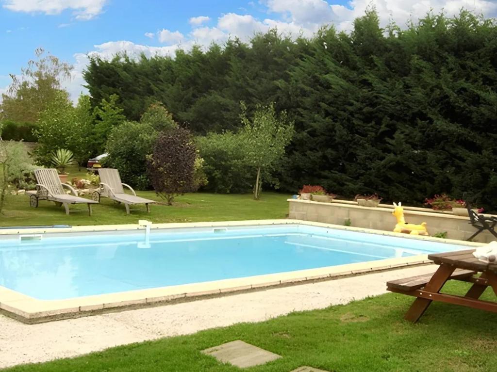 ErvauvilleにあるVilla de 4 chambres avec piscine privee jardin clos et wifi a Ervauvilleの庭園内のスイミングプール(椅子2脚、テーブル付)