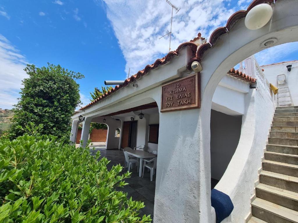 Una casa con un cartel en el costado. en Το Κτήμα της Ελιάς του Τάκη, en Paralia Demonias