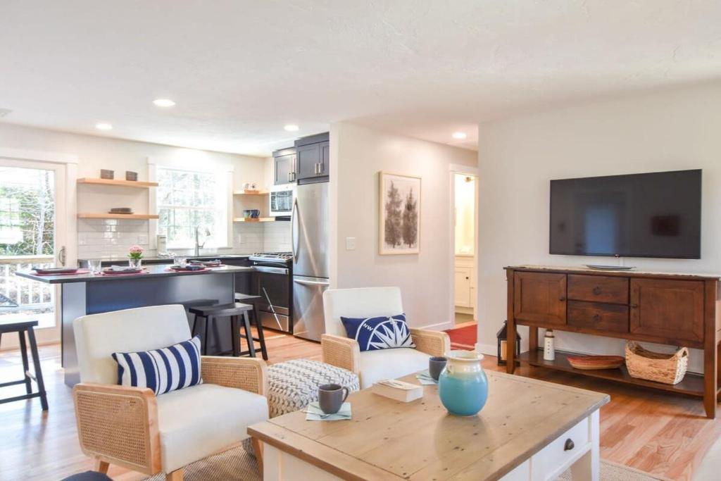 a living room with a table and a kitchen at Fully Updated Home w Great Outdoor Space in Chatham