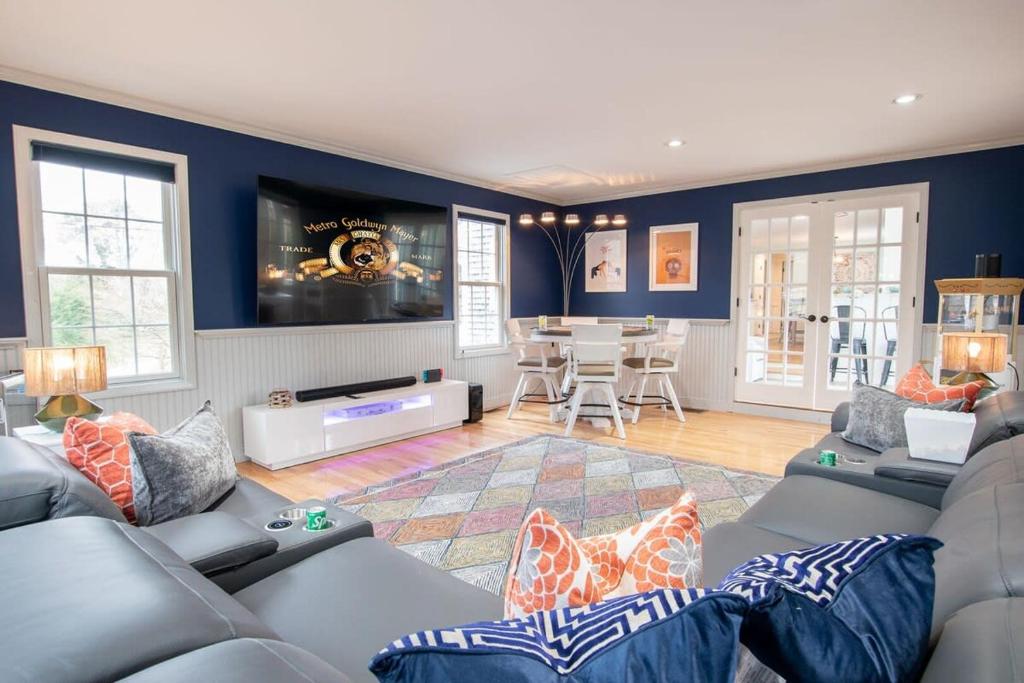 a living room with blue walls and couches at Stellar Home with Hot Tub & Movie Room in Chatham