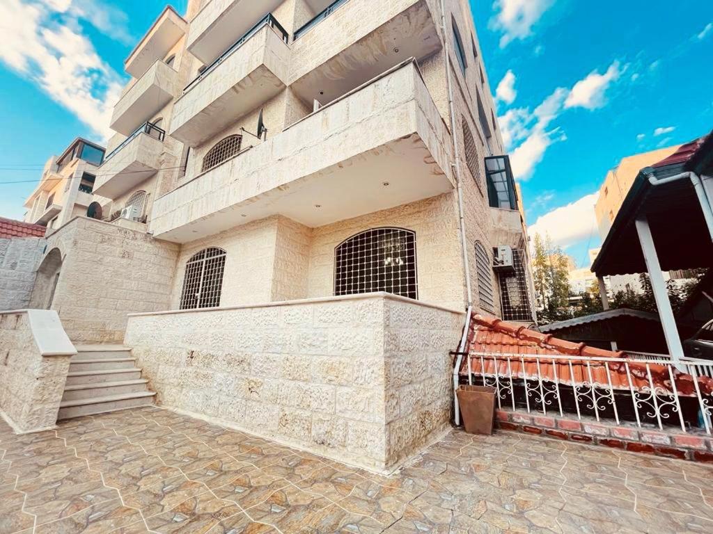 a building with a staircase in front of it at Spacious family friendly apartment - Free Barking in Amman