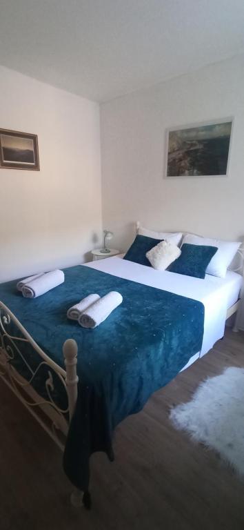 um quarto com uma cama grande com lençóis e almofadas azuis em Home Sea of Serenity em Ston
