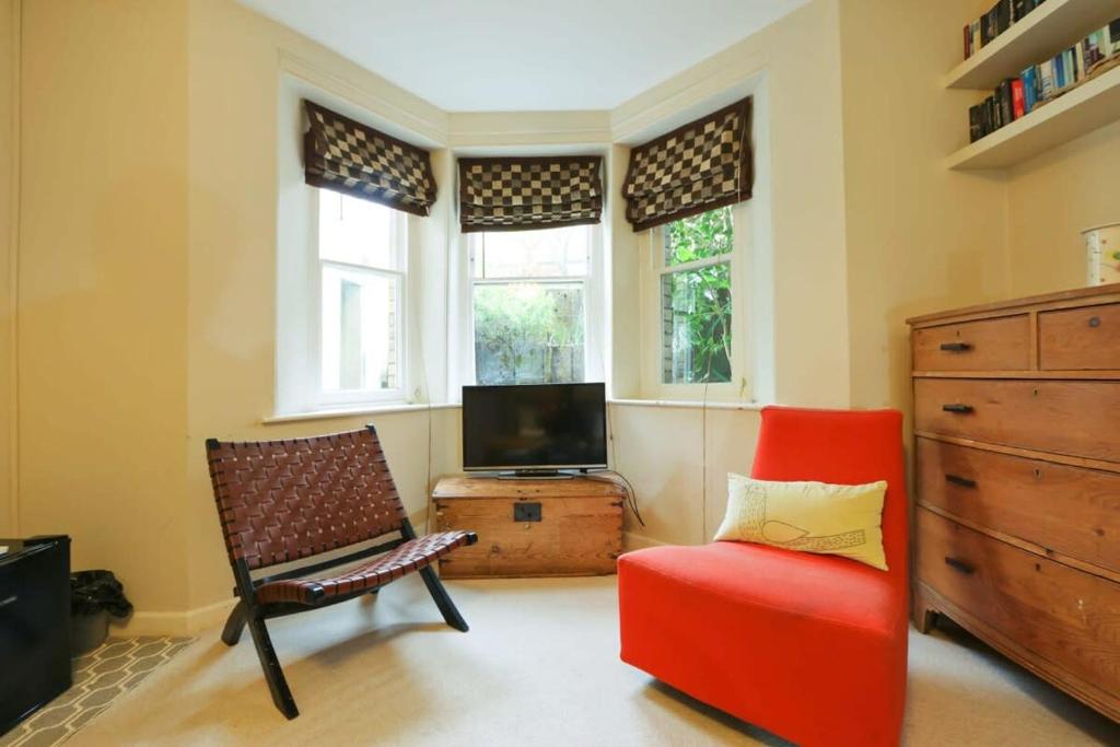 un soggiorno con sedia e TV di Unique & Homely Suite With Own Access a Bristol