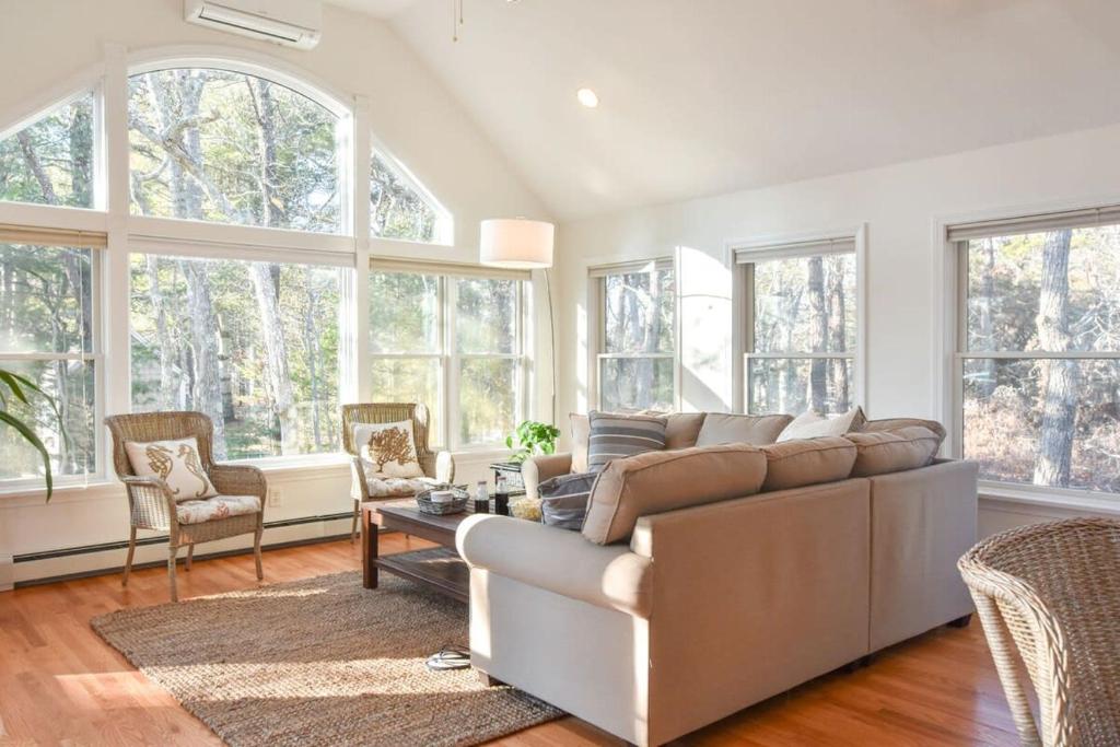 sala de estar con sofá grande y ventanas en 5-Mins to Forest Beach Dog Friendly, en Chatham